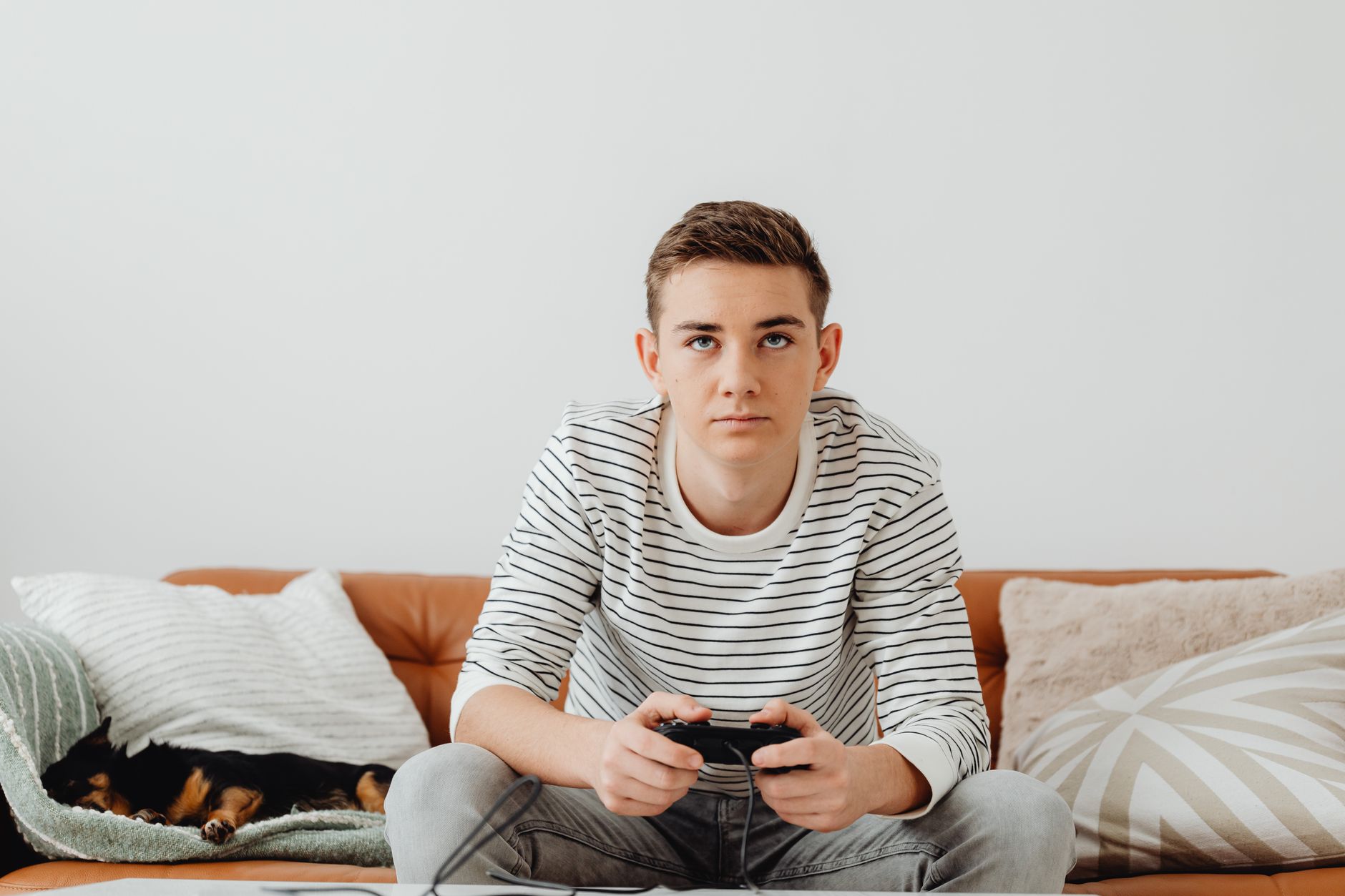 Teen boy intensely focused on video games at home, relaxing on a couch. — 10 Tips to Help You Gamble Safely Online