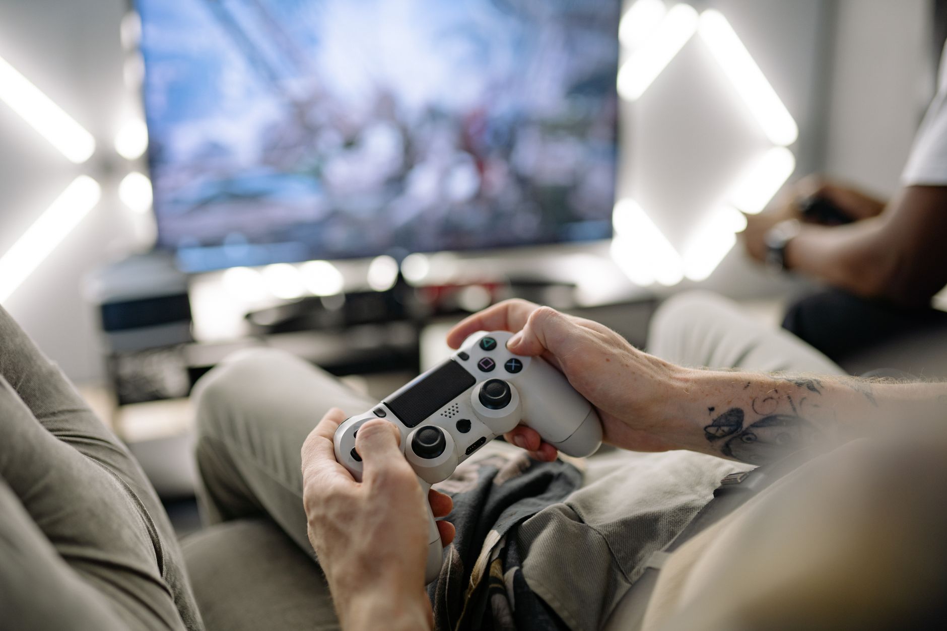 Hands holding a video game controller in a modern living room, playing on TV. — CUAN88 Login and Registration Guide for New U