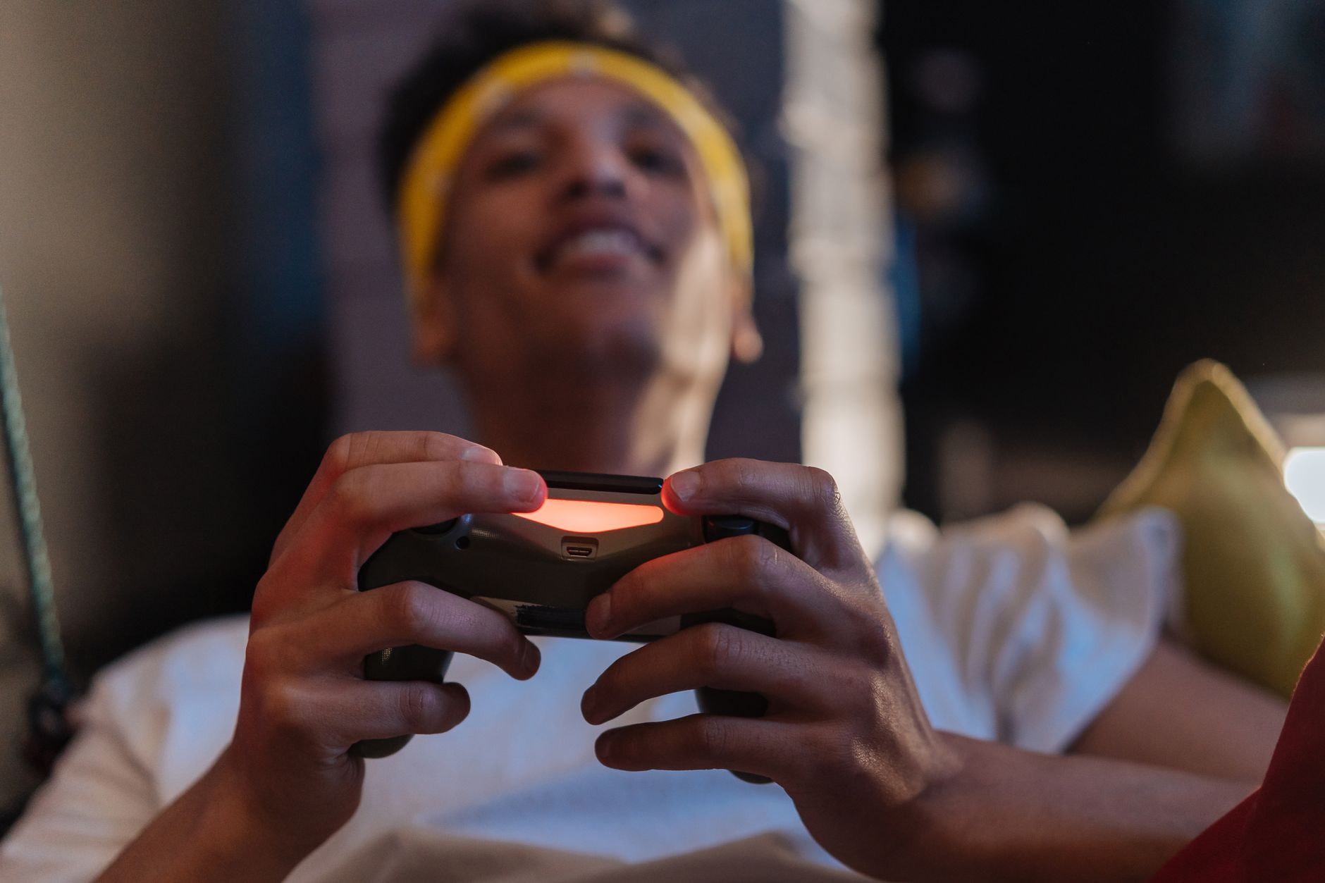A relaxed gaming session with a close-up view of a man holding a game controller indoors. — Helpful Tips For Playing Online C
