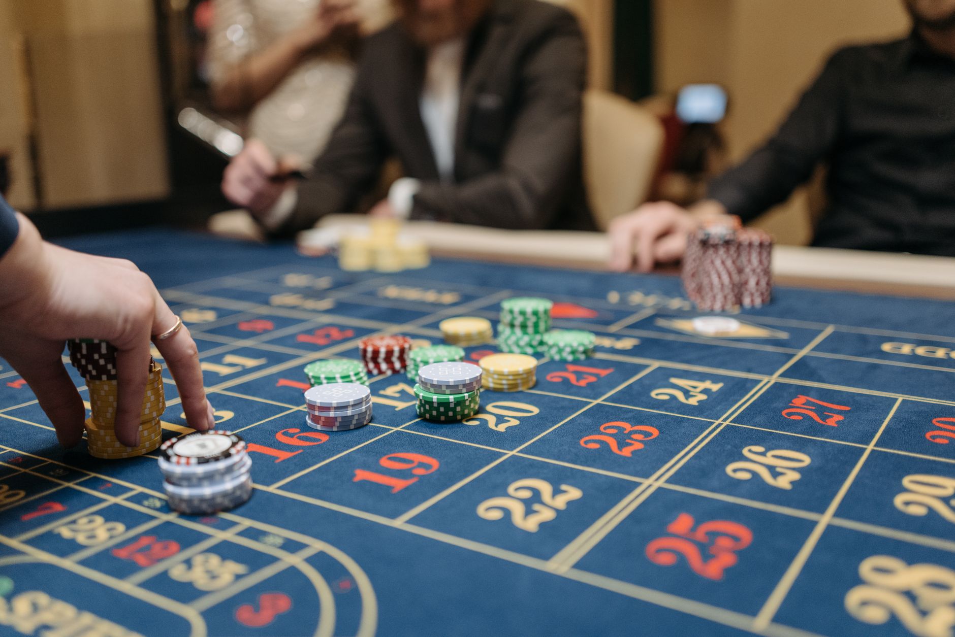 Hands placing betting chips on a roulette table in an upscale casino setting. — How a beginner is going to be took advantage
