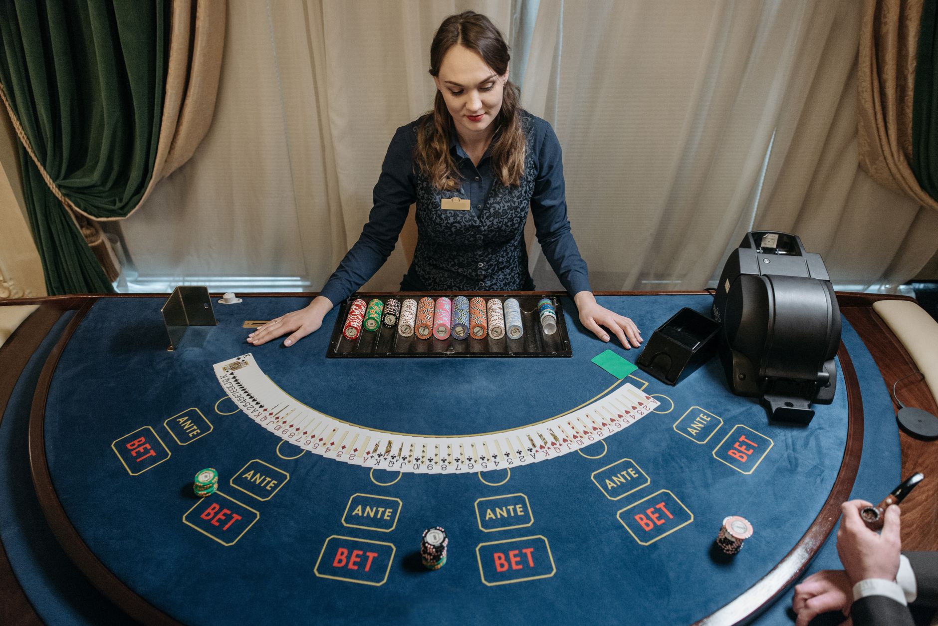 Professional female casino dealer managing a gaming table with chips and cards in a luxurious setting. — How Internet Casino