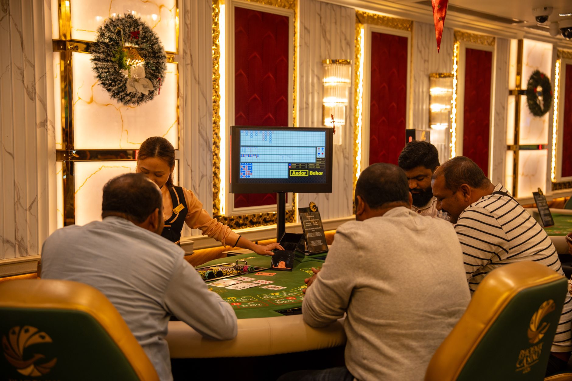 A group of adults playing at a casino table in Goa, India, captured indoors with festive decor. — KOITOTO Toto Macau Site Rev