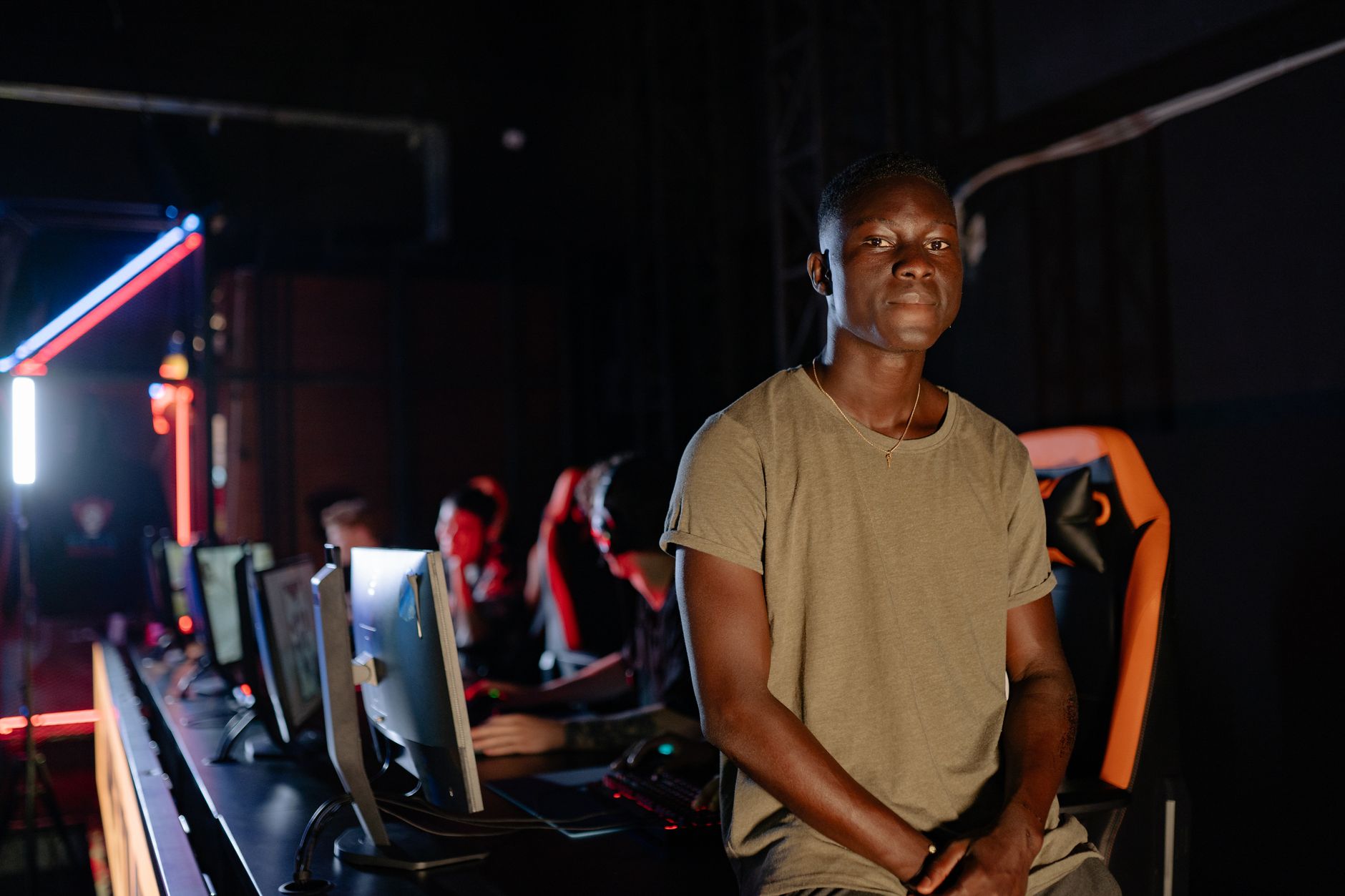 A young gamer in a dimly lit gaming arena, surrounded by teammates. — nternet casino gamble- Get numerous choices for gamble