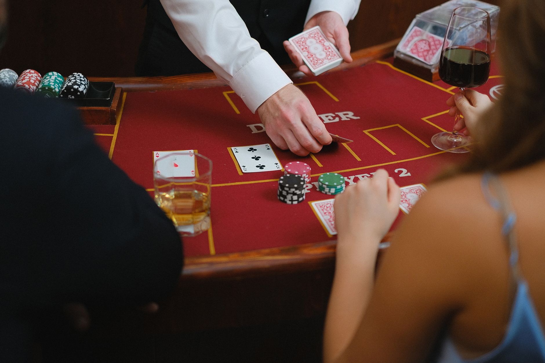 A dynamic scene at a casino card table with players engaged in a game featuring poker chips and drinks. — Pick the online bet