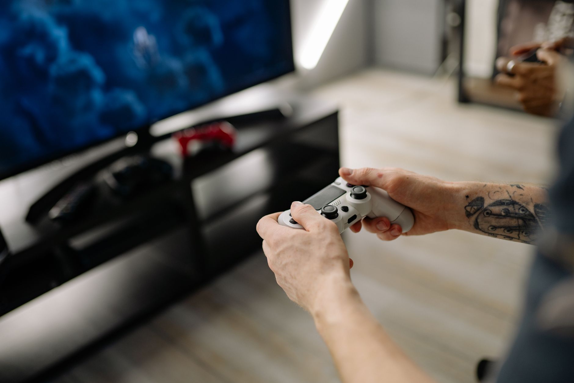 Person playing video games using a game controller indoors on a modern TV setup. — PLAYERS CAN EARN ON-LINE INTERNET CASINO G