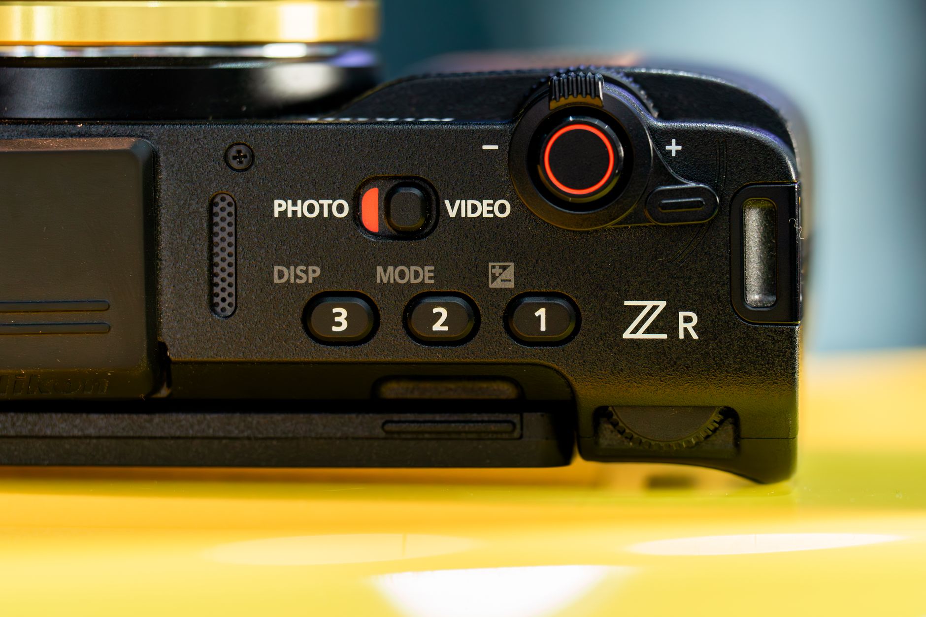 Detailed close-up of a camera's control interface featuring buttons and dials, emphasizing its design and functionality. —