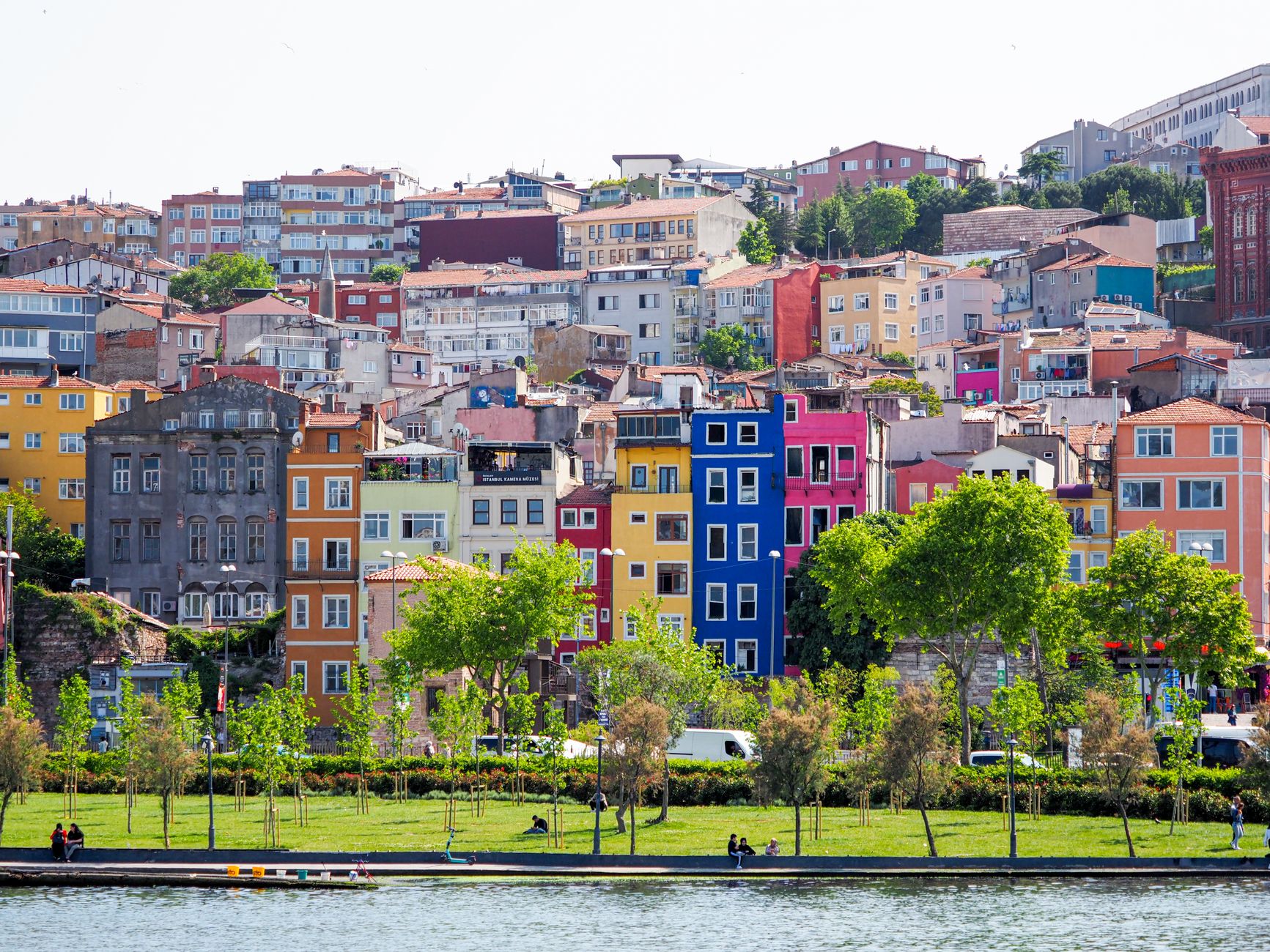 Vibrant multi-colored facades in a residential district of Istanbul, Turkey, with green park and trees. — Taking Adva