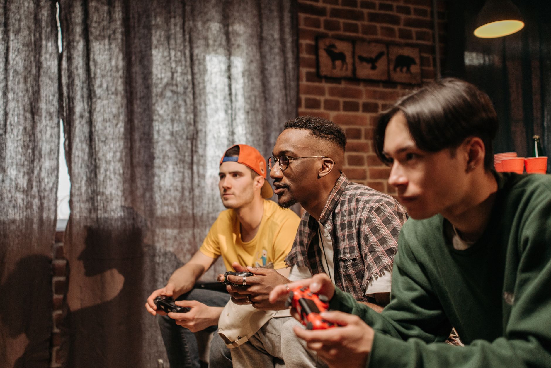 Three men focused on playing video games with controllers indoors. — The Different Game Modes Available on Major site