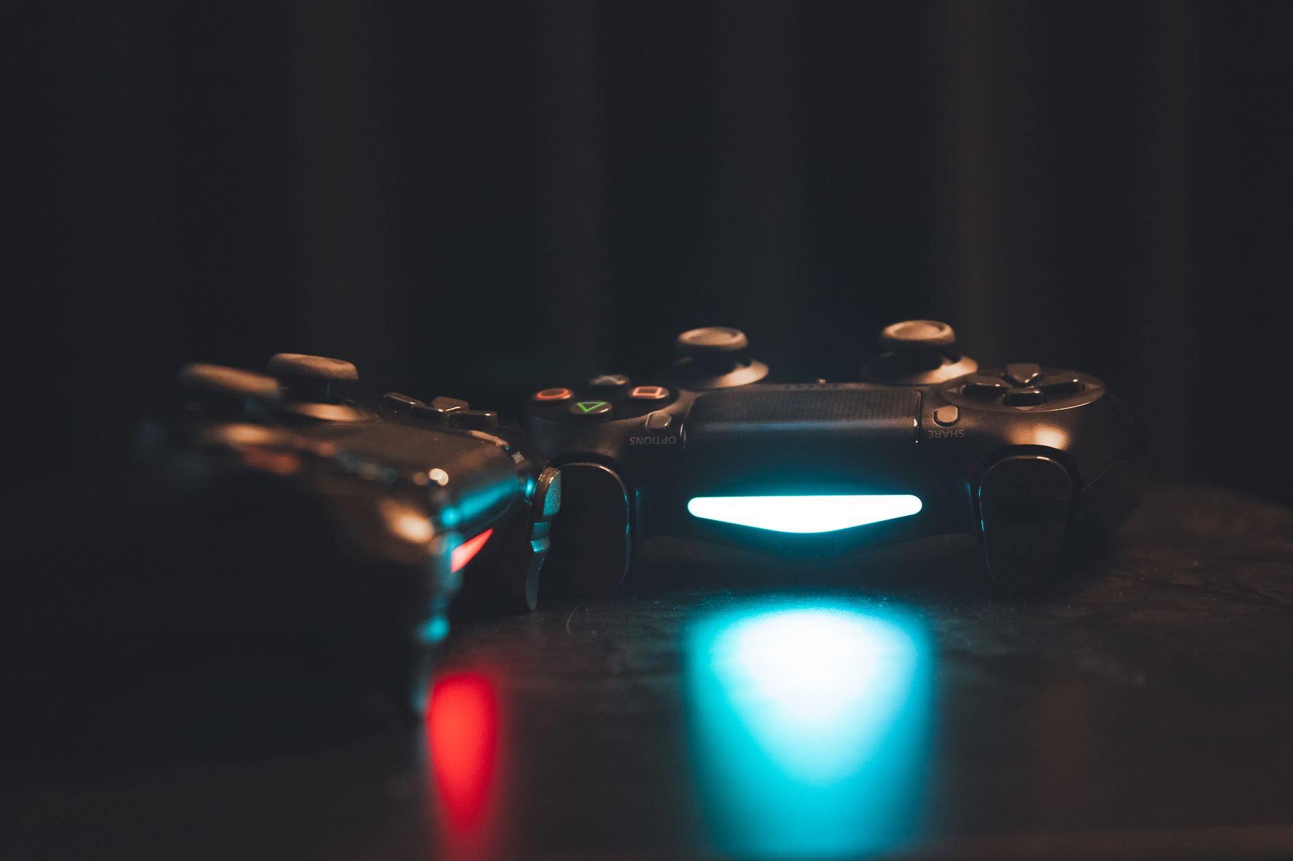 Close-up of glowing gaming controllers on a dark surface, creating a moody ambiance. — System Performance Trends of MPOID Alt