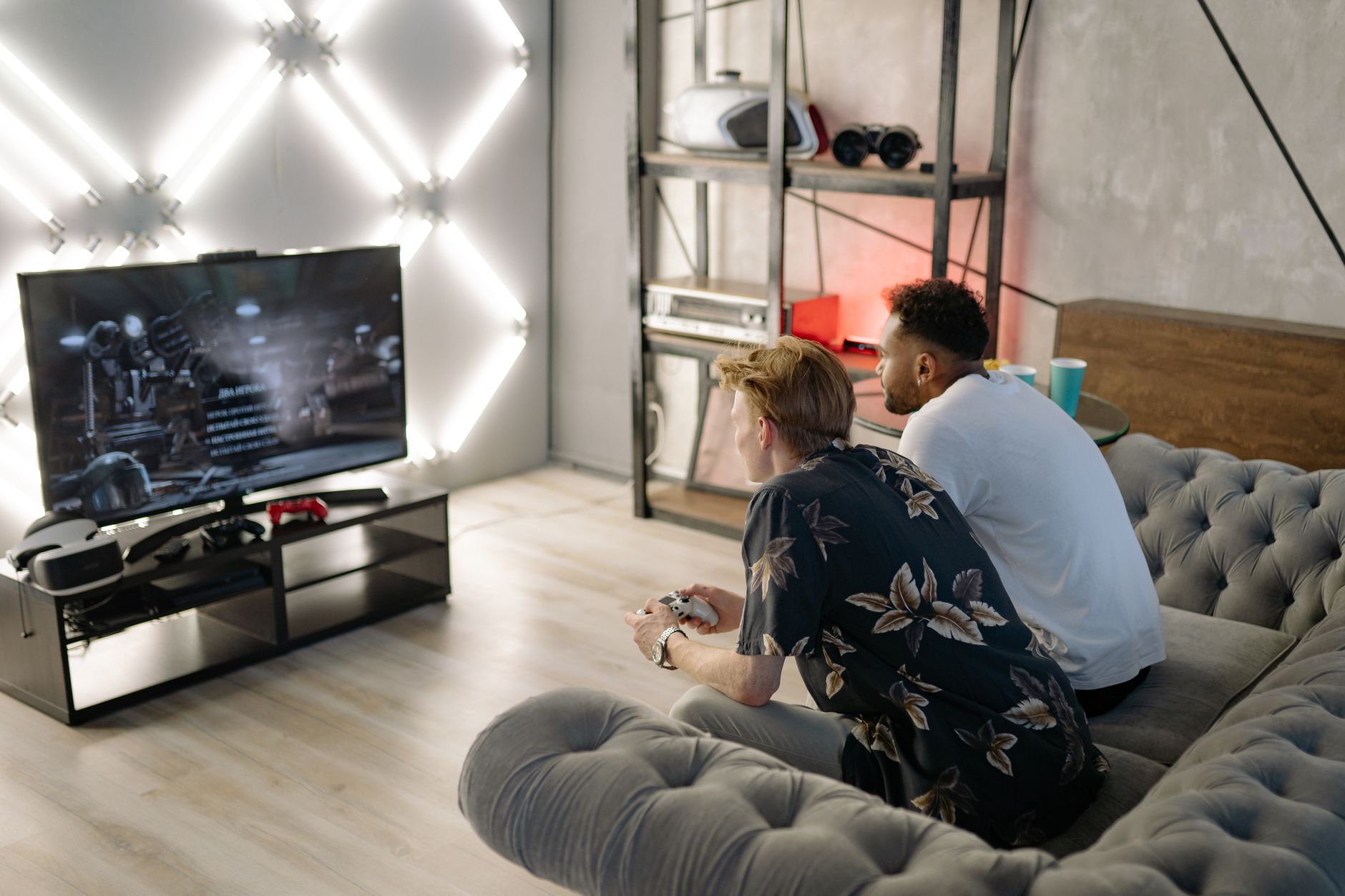 Two young men gaming together in a stylish modern living room with a large TV. — The Advantages Of Playing sexy baccaratOn Ki