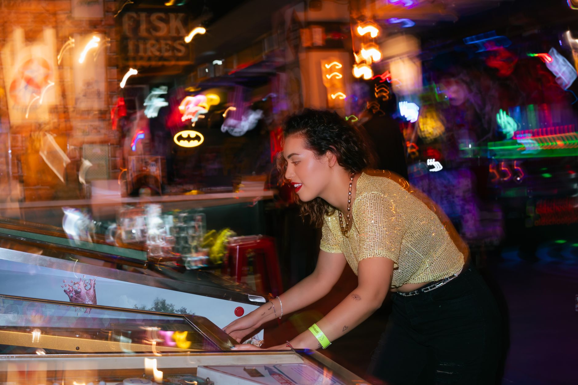 Young woman enjoying a night out playing pinball in an energetic arcade setting. — The Ultimate Guide To Betting Sites: How T