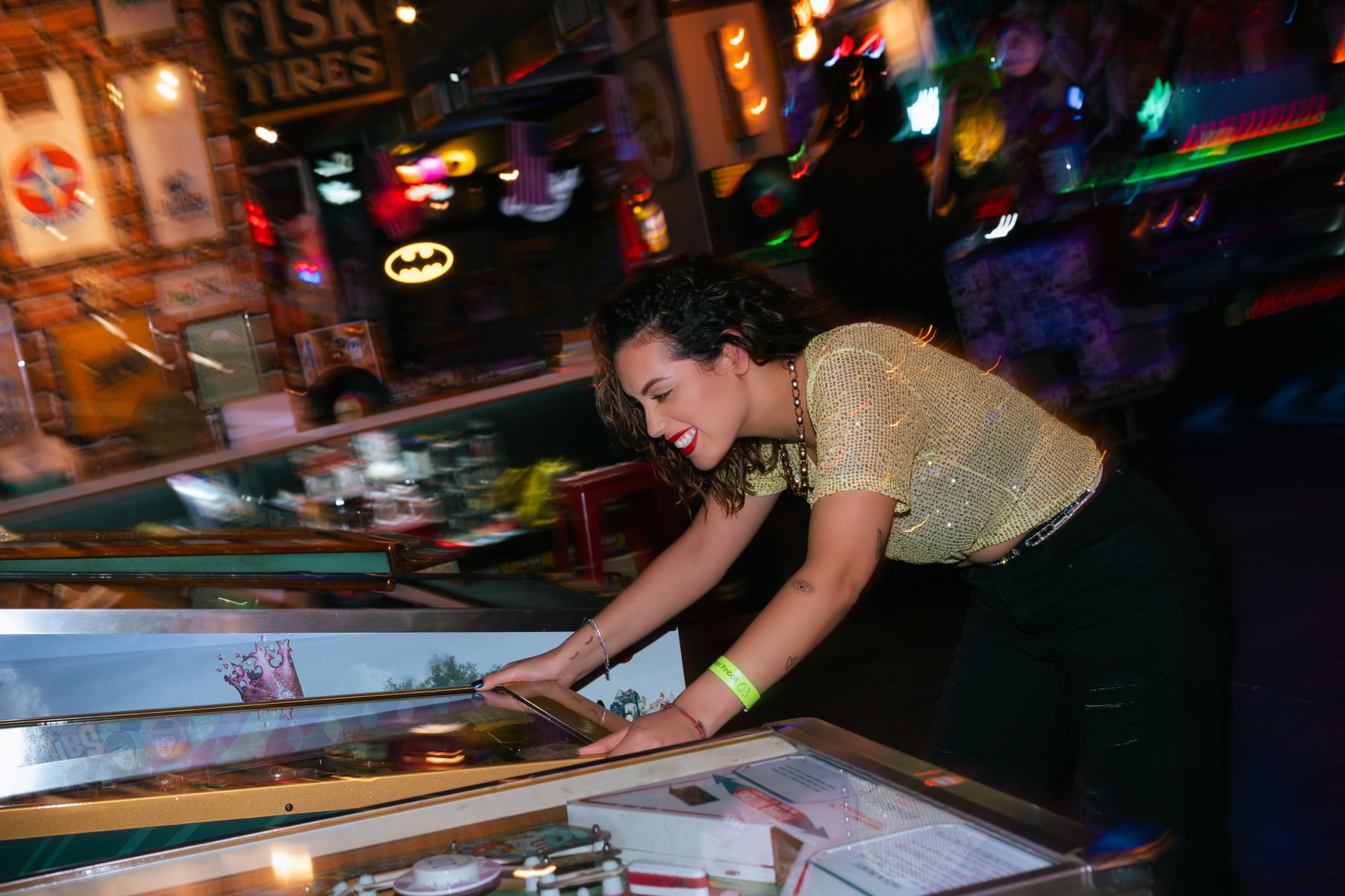 A woman cheerfully plays pinball in a vibrant, colorful arcade setting, embodying fun and entertainment. — Things to consider