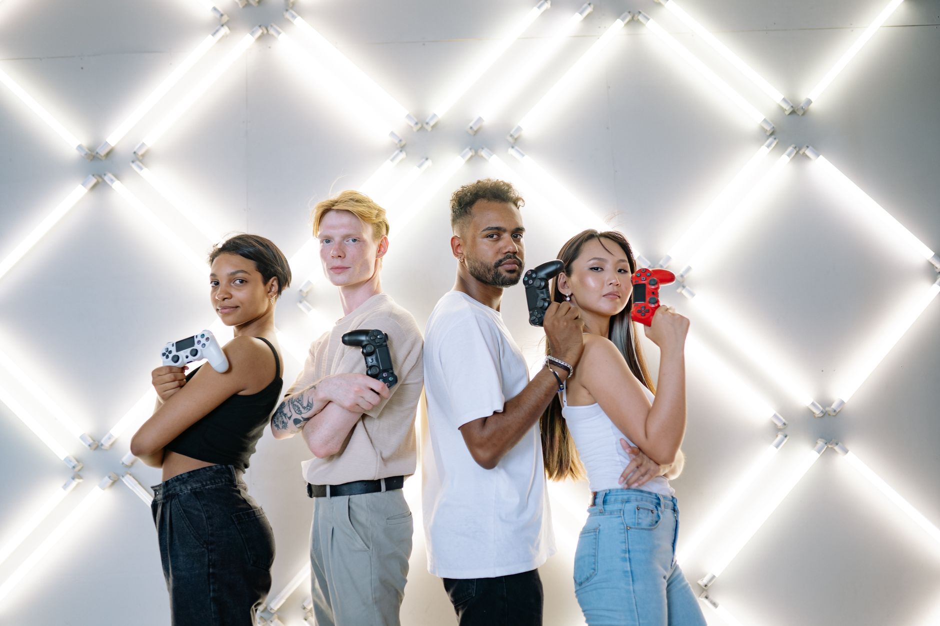 Four diverse friends posing confidently with game controllers against a modern LED backdrop. — Various professional services