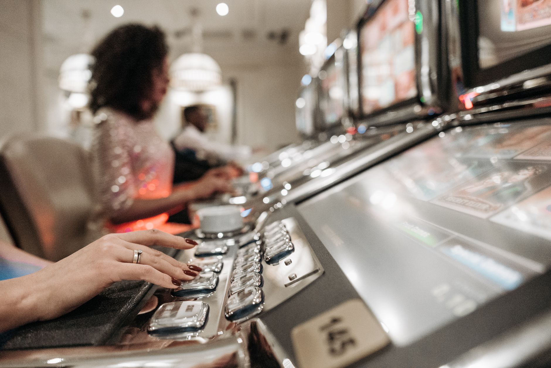 Close-up view of hands playing slot machines in a casino setting. — What are the benefits of online football betting?