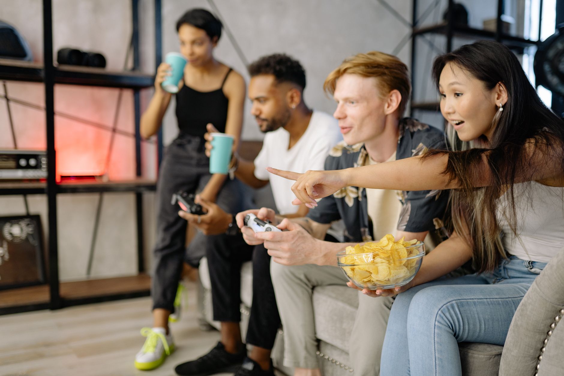 Diverse group of friends enjoying video games and snacks in a cozy living room setting. — What are the different variations o